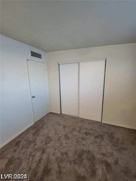 unfurnished bedroom featuring a closet and carpet flooring