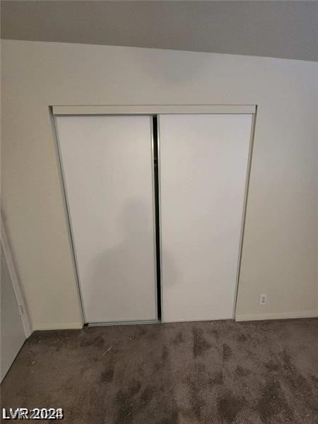 interior space featuring a closet and dark carpet