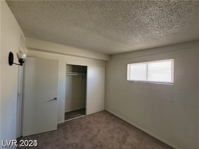 unfurnished bedroom featuring a textured ceiling and a closet