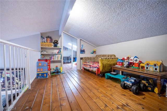 game room with a textured ceiling, vaulted ceiling, and hardwood / wood-style floors