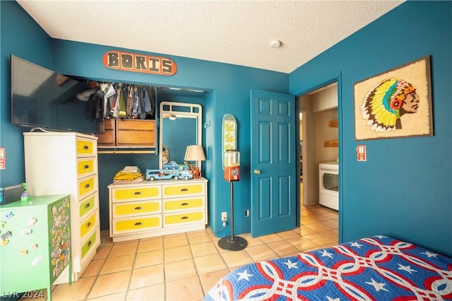 tiled bedroom with a textured ceiling and washer / clothes dryer