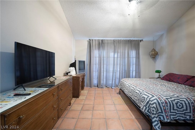 bedroom with light tile patterned flooring and a textured ceiling