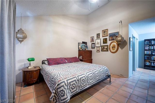 bedroom featuring a ceiling fan, a textured ceiling, and tile patterned floors