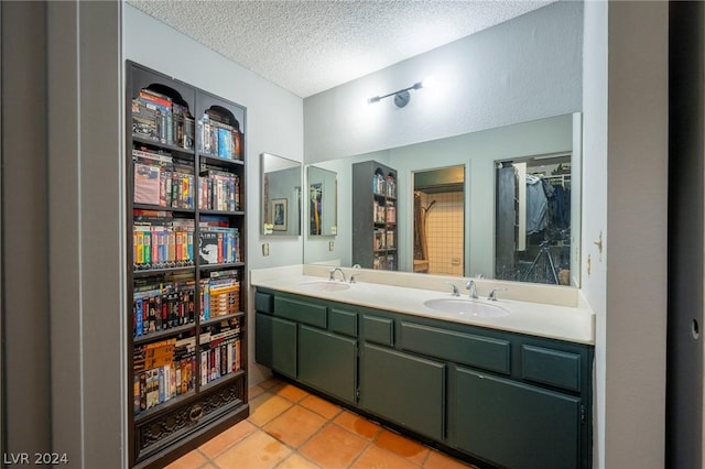 full bathroom featuring a textured ceiling, double vanity, a sink, and a walk in closet