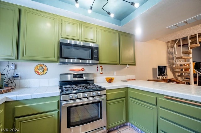 kitchen featuring a peninsula, visible vents, tile counters, and stainless steel appliances