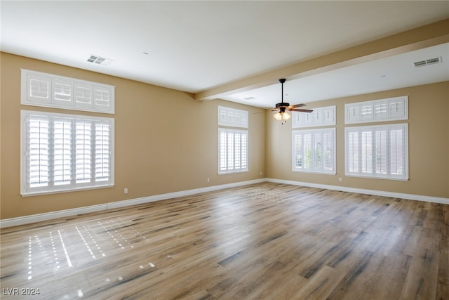 unfurnished room featuring ceiling fan, beam ceiling, and light wood-type flooring