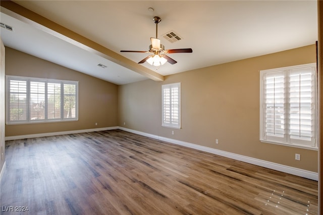 empty room with hardwood / wood-style floors, lofted ceiling with beams, and ceiling fan