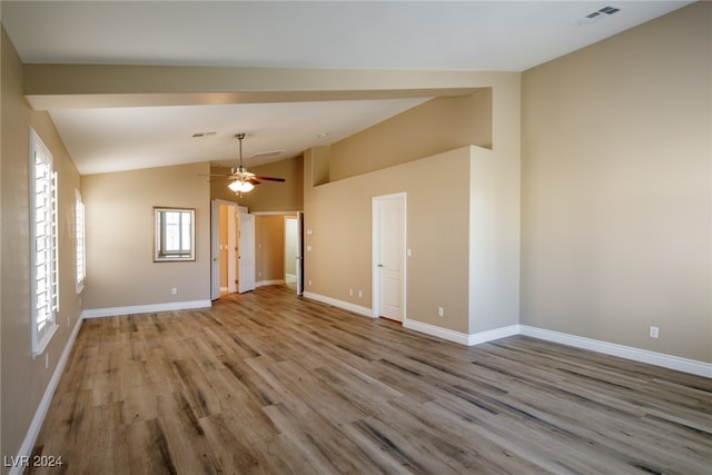 spare room featuring light hardwood / wood-style floors, vaulted ceiling, and ceiling fan