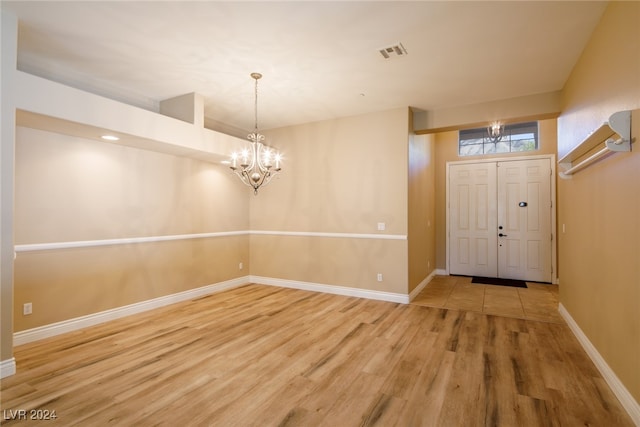 entryway featuring wood-type flooring and a chandelier