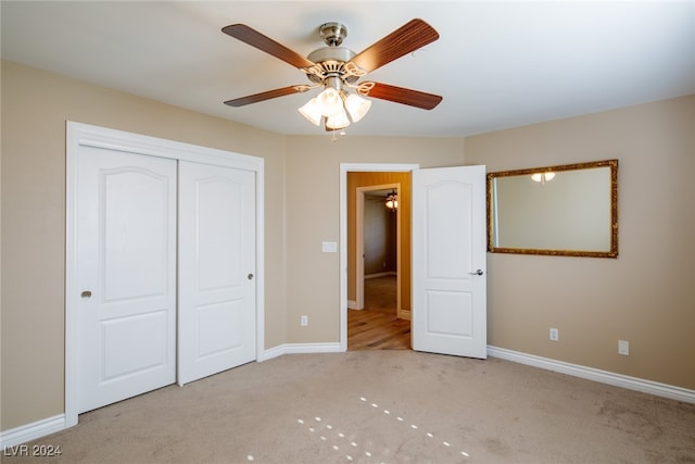 unfurnished bedroom featuring light carpet, a closet, and ceiling fan