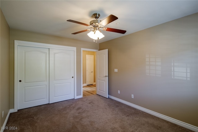 unfurnished bedroom featuring a closet, light colored carpet, and ceiling fan