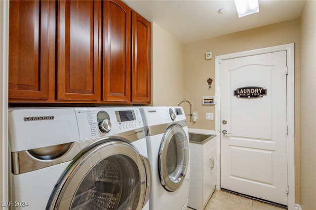 washroom with light tile patterned flooring, independent washer and dryer, and cabinets