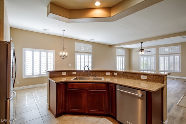 kitchen featuring sink, stainless steel appliances, ceiling fan with notable chandelier, and plenty of natural light