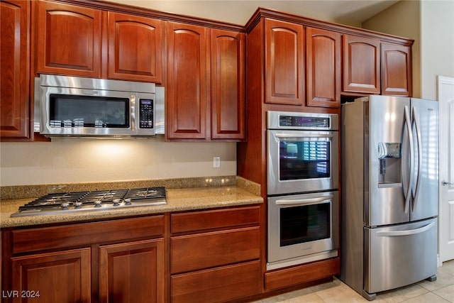 kitchen featuring light stone counters, appliances with stainless steel finishes, and light tile patterned floors