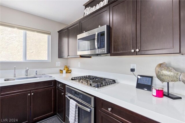 kitchen featuring dark brown cabinetry, appliances with stainless steel finishes, and sink