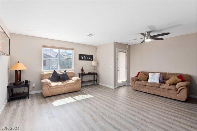 living room featuring ceiling fan and light hardwood / wood-style floors