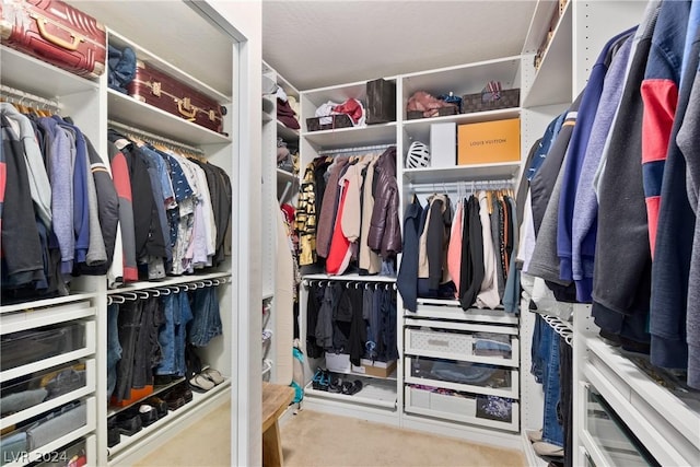 walk in closet featuring light carpet