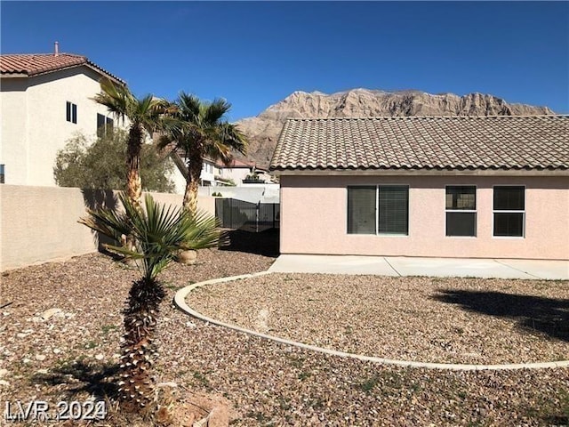 rear view of property featuring a mountain view and a patio area