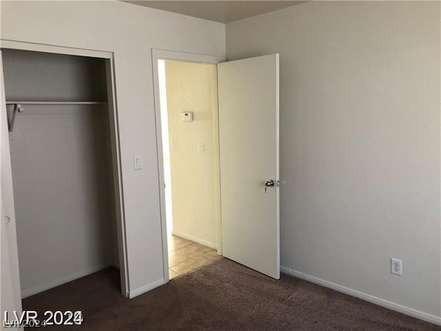 unfurnished bedroom featuring carpet floors and a closet