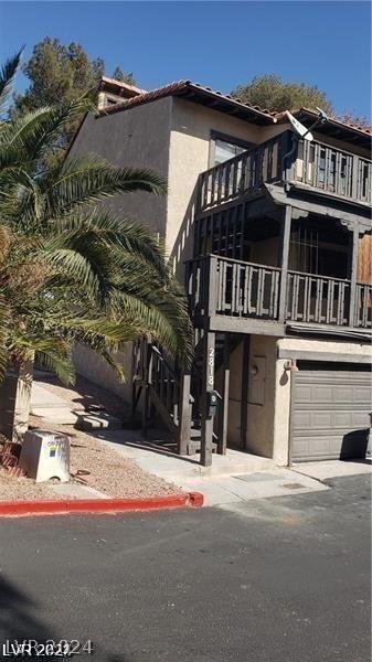 view of front of property featuring a balcony and a garage