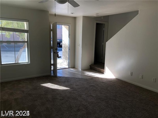 unfurnished room with ceiling fan, a wealth of natural light, and carpet flooring