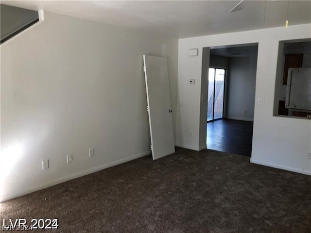 unfurnished room featuring dark colored carpet