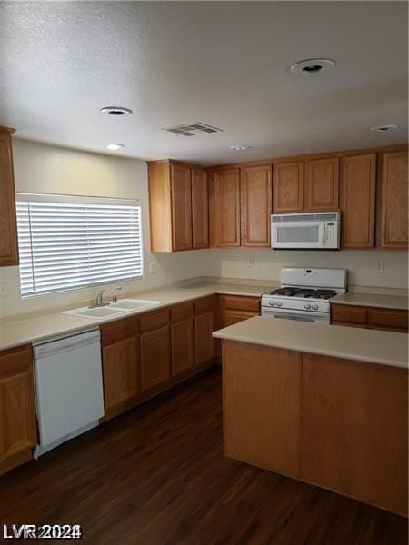 kitchen with dark hardwood / wood-style flooring, sink, and white appliances