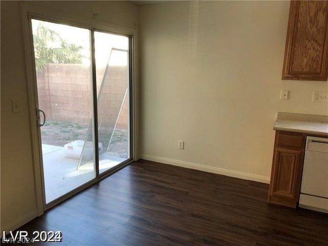 unfurnished dining area featuring dark wood-type flooring and a healthy amount of sunlight