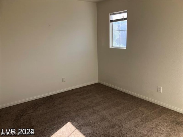 unfurnished room featuring dark carpet