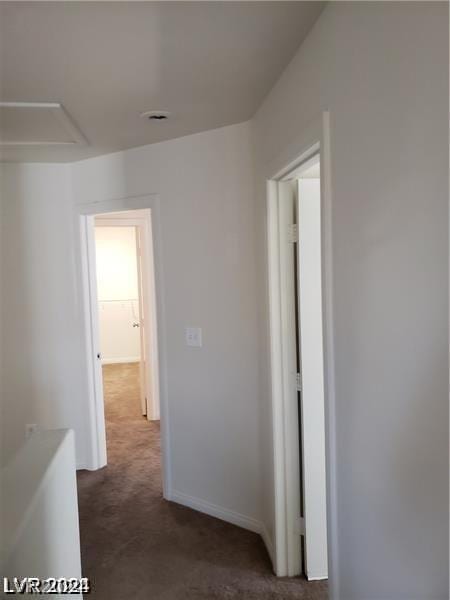 hall featuring dark colored carpet