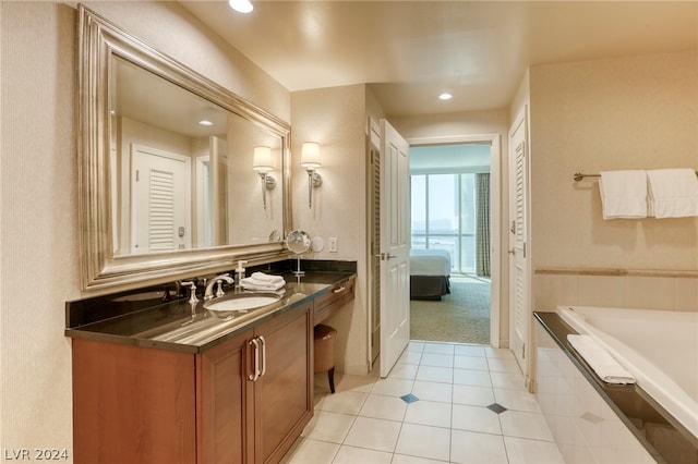 bathroom featuring vanity, a relaxing tiled tub, and tile patterned floors