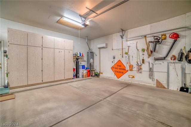 garage featuring water heater, a garage door opener, a wall unit AC, and a workshop area