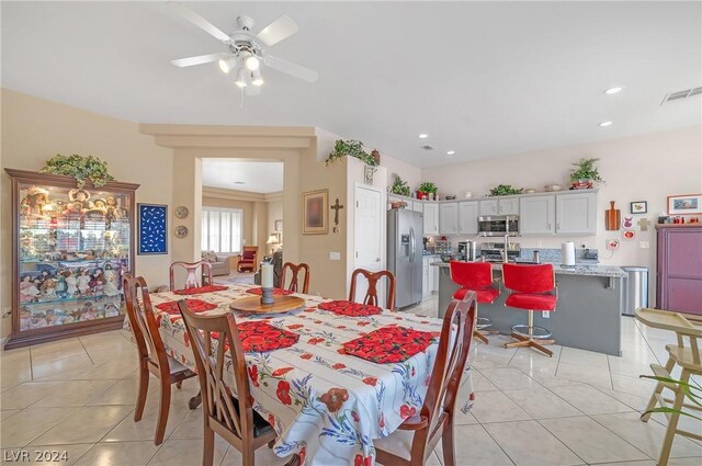 tiled dining space featuring ceiling fan