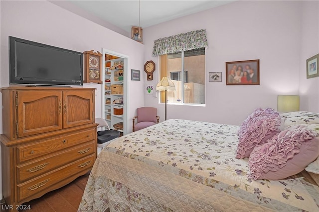 bedroom featuring wood-type flooring, a spacious closet, and a closet