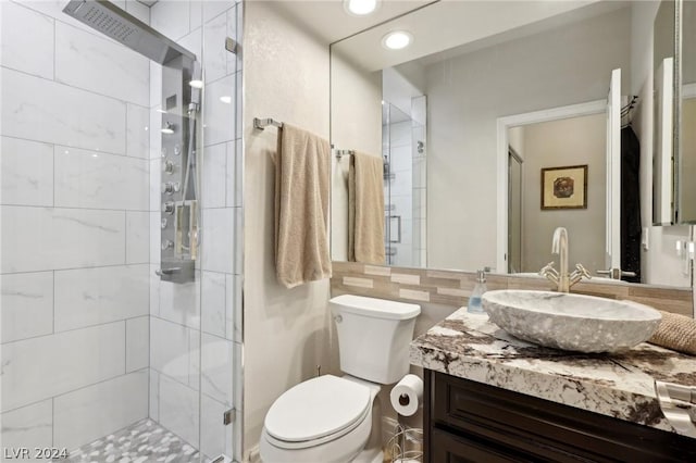 bathroom featuring vanity, toilet, and a shower with shower door