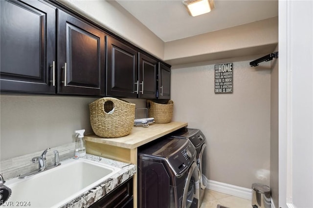 clothes washing area featuring washer and dryer, light tile patterned floors, cabinets, and sink