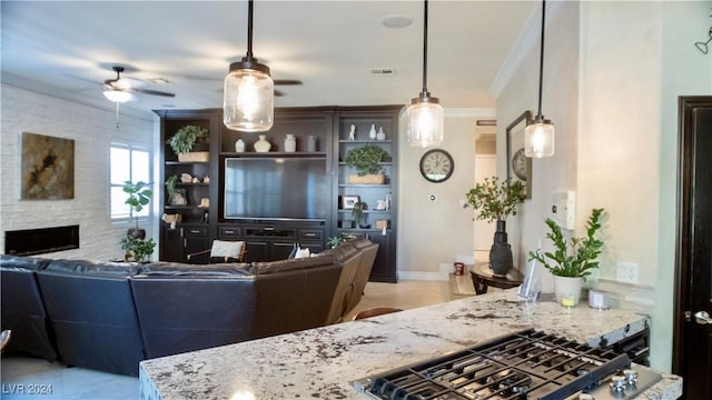 tiled living room with a stone fireplace, ceiling fan, and ornamental molding