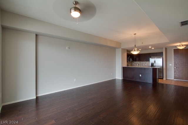 unfurnished living room featuring ceiling fan and dark wood-type flooring