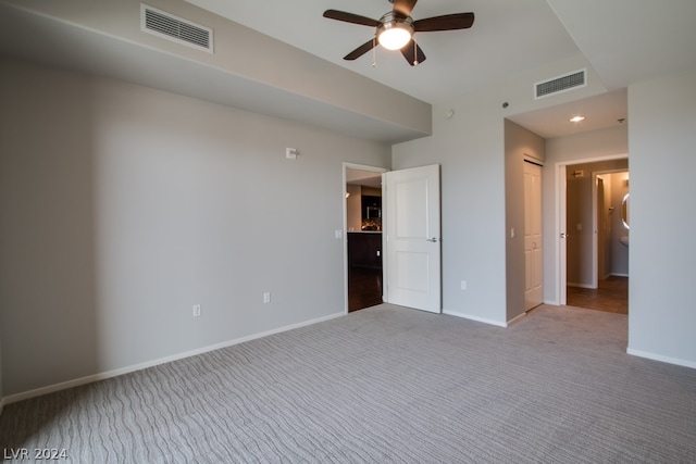 unfurnished bedroom with ceiling fan, light colored carpet, and a closet