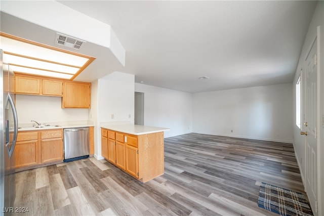 kitchen featuring sink, kitchen peninsula, light wood-type flooring, and stainless steel appliances