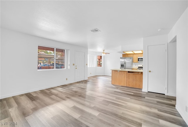 unfurnished living room with light wood-type flooring and ceiling fan