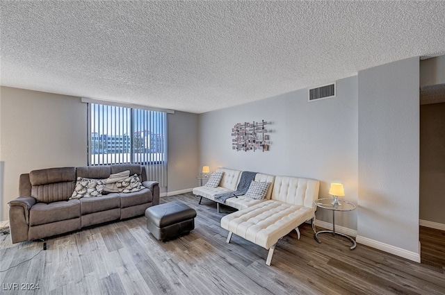 living room with wood-type flooring and a textured ceiling