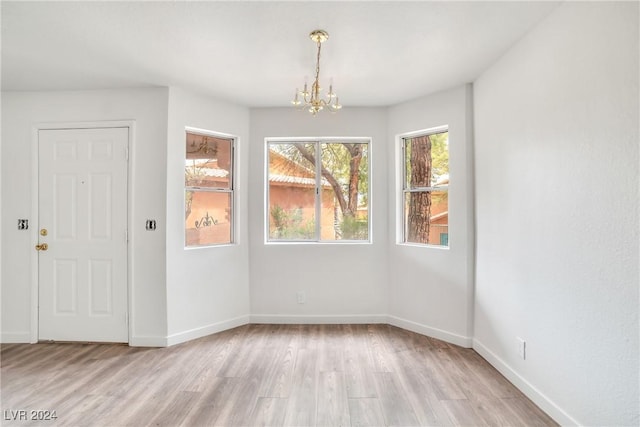 845 Mesquite Springs Dr Unit 101, Mesquite, NV 89027 - unfurnished dining area featuring baseboards, an inviting chandelier, and light wood-style flooring