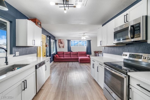 kitchen with ceiling fan, light hardwood / wood-style flooring, stainless steel appliances, and white cabinetry