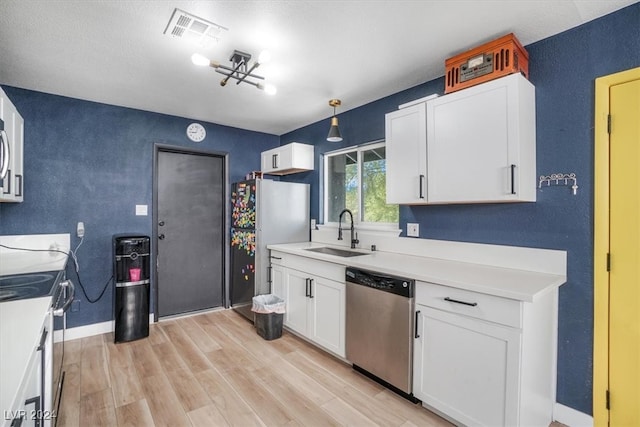 kitchen featuring sink, white cabinets, hanging light fixtures, light hardwood / wood-style flooring, and appliances with stainless steel finishes