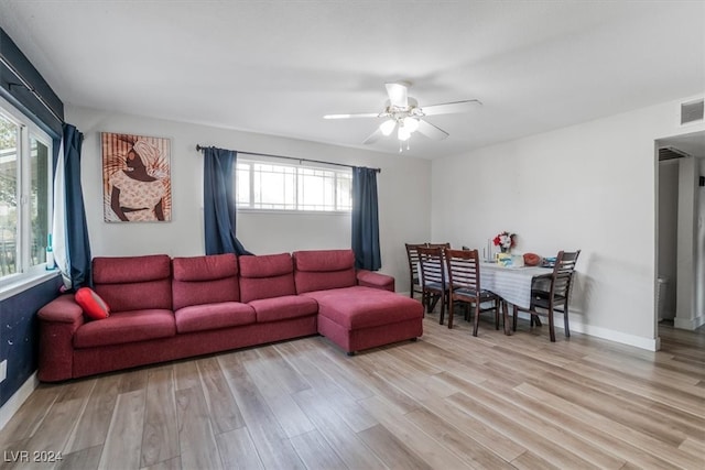 living room featuring ceiling fan, light wood-type flooring, and plenty of natural light