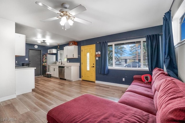 living room featuring light hardwood / wood-style flooring, ceiling fan, and sink