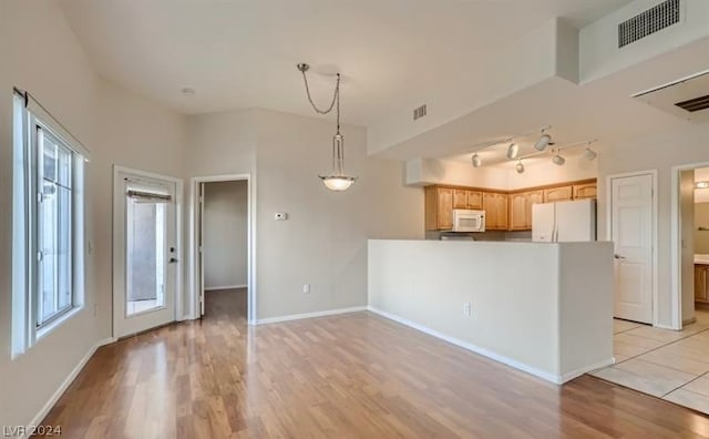 kitchen featuring light hardwood / wood-style floors, lofted ceiling, and white appliances