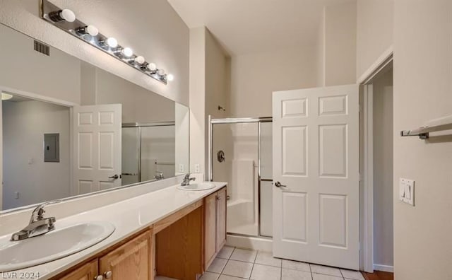 bathroom with a shower with door, double vanity, tile patterned floors, and electric panel