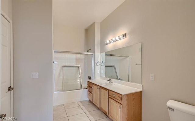 full bathroom with shower / bath combination with glass door, vanity, tile patterned flooring, and toilet